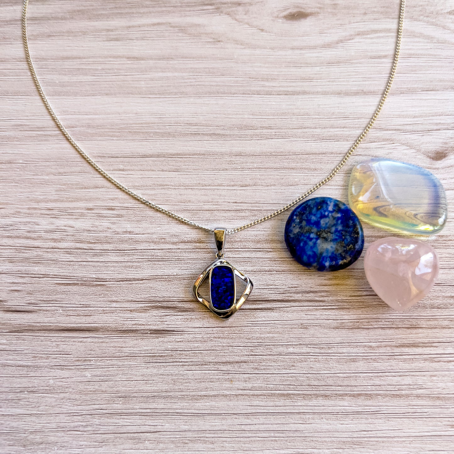 Sterling Silver Doublet Opal Pendant. The pendant features a rounded rectangle-cut opal doublet set in a twist diamond design, showcasing deep blues and greens. - Opalist