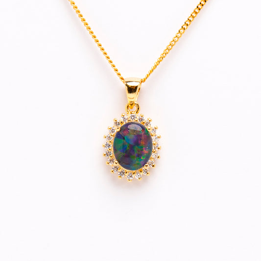 Gold-Plated Sterling Silver Triplet Opal Pendant. The pendant features an oval-cut triplet opal in vibrant shades of green, yellow, red, and blue. The opal is claw-set with a halo design adorned with cubic zirconia | Opalist